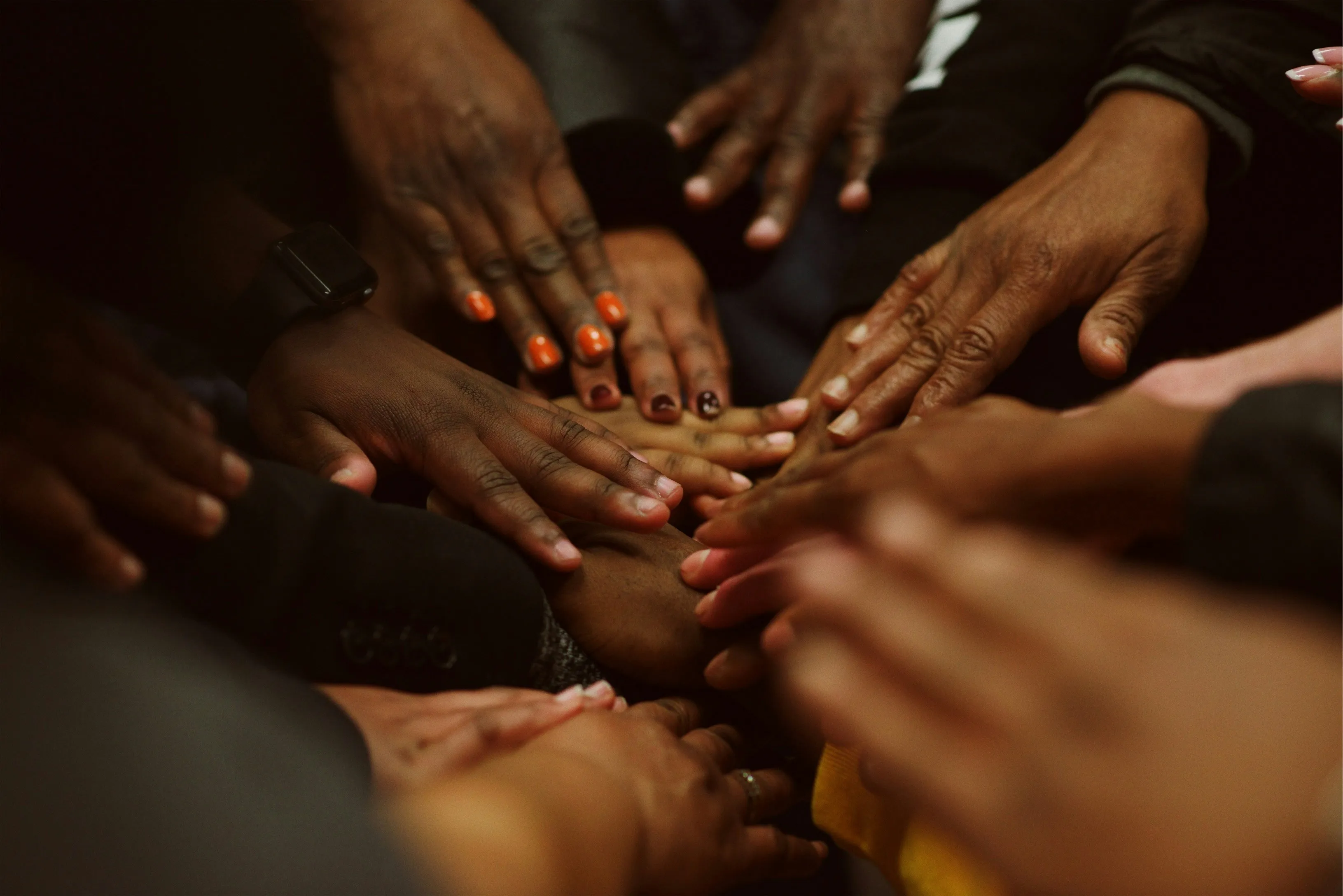 A close-up of diverse hands joined together, symbolising community and solidarity