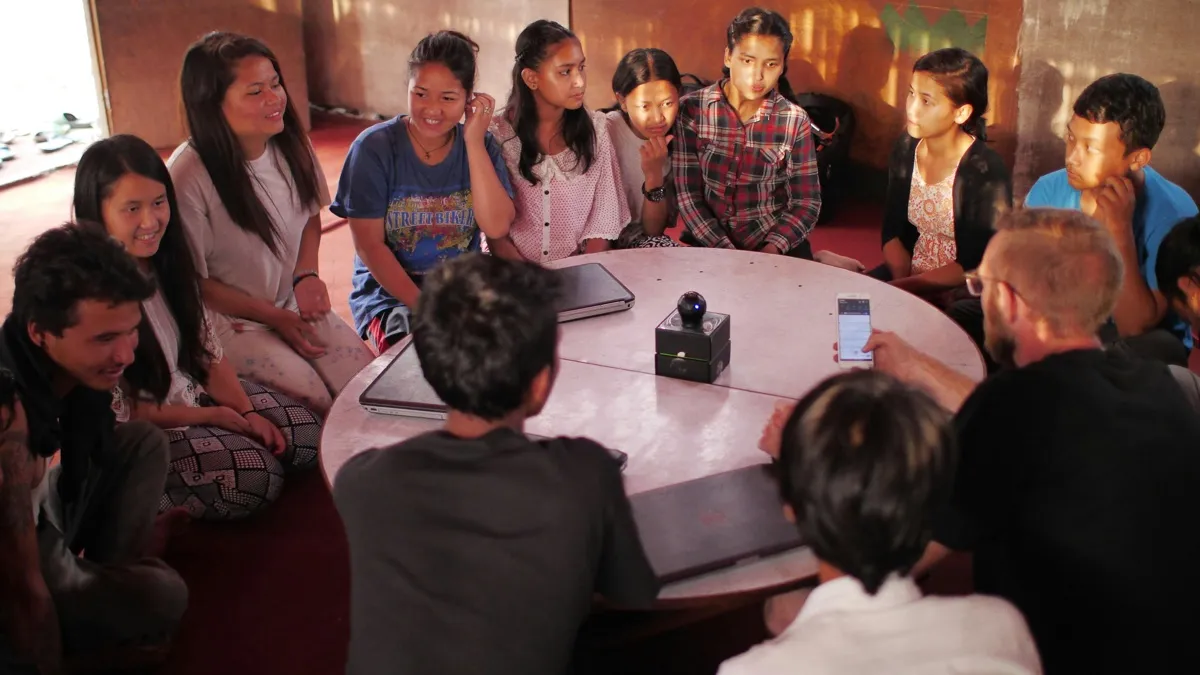 A peer-led student council gathered around a round table in animated discussion