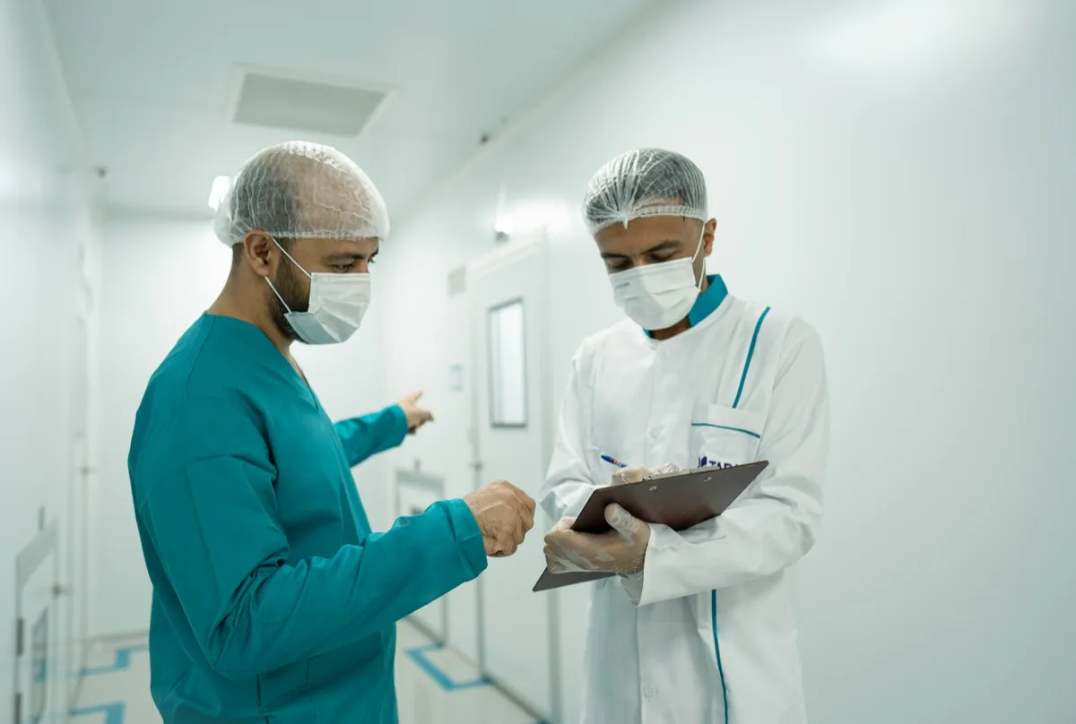 Two healthcare workers reviewing a patient note, embodying global health collaboration
